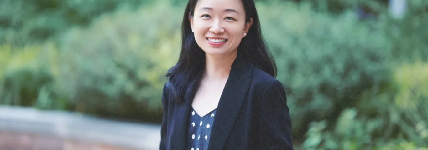 Photo of Peng Peng smiling to camera in a black blazer and patterned top