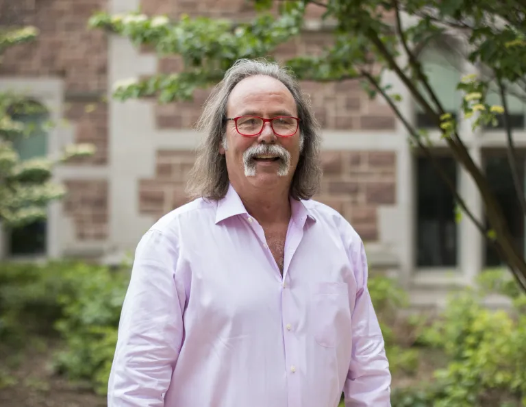 Photo of James Gibson smiling in a pink button down shirt