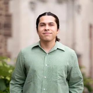Photo of Jose Santiesteban smiling in a green button-up shirt